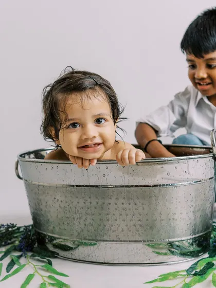 Sometimes older siblings want to join the fun. I couldn't say no to this adorable moment during a first birthday bathtub splash. It's a beautiful memory of brotherly love.