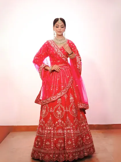 Another full-length shot of the red and pink lehenga, showing its elegant silhouette.
