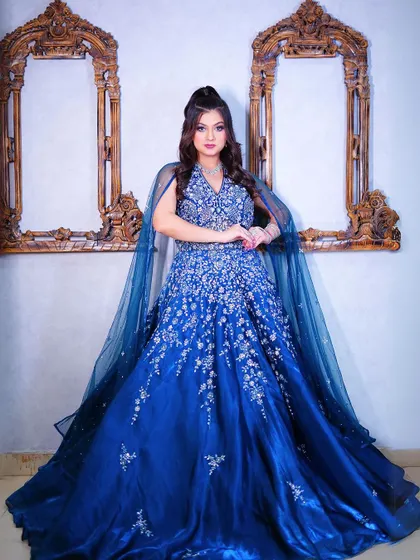 A full-length view of the blue ball gown against a classic studio backdrop.