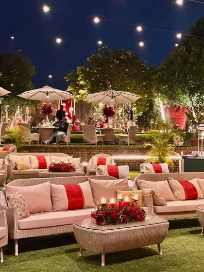 A "Scarlet Symphony" theme. The lounge seating is accented with deep red cushions, and the tables are adorned with red floral centerpieces.