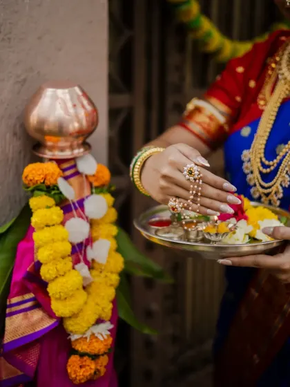 A close-up shot focusing on the details of the Gudi Padwa ritual. This image highlights the model's hands, adorned with beautiful jewelry, as she offers flowers to the Gudi, symbolizing new beginnings.