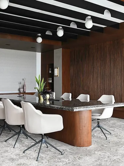 A dynamic shot of the conference room, showing the length of the space and its connection to the bright, window-lined corridor.