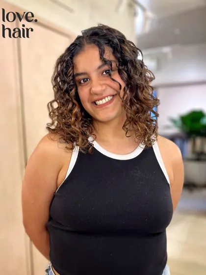 The client smiling with her new curly cut and color. We love helping our clients embrace and love their natural curls.