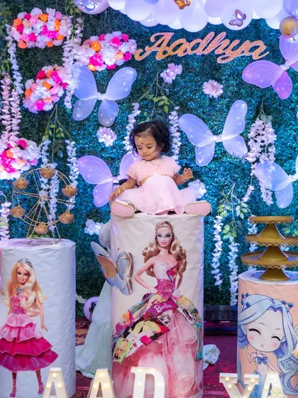 A sweet portrait of the birthday girl sitting atop a decorated pedestal at her Barbie-themed party. These posed shots are perfect for creating lasting keepsakes from the celebration.