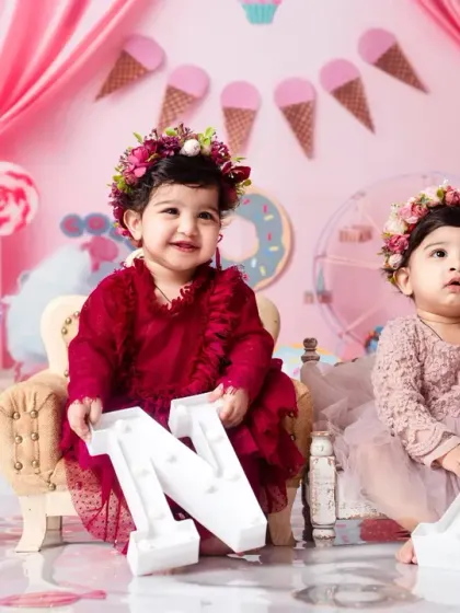 All smiles from these twin girls during their 'ONE' birthday photoshoot, surrounded by donuts and ice cream props.