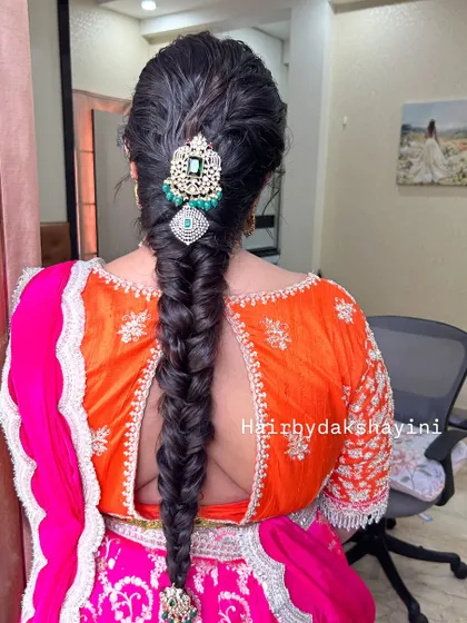 A clear, centered shot of the fishtail braid with a statement emerald and diamond hair accessory.