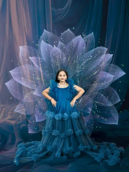 Bold and beautiful. This dramatic maternity portrait in a stunning blue gown with an artistic floral background celebrates the strength and grace of motherhood.
