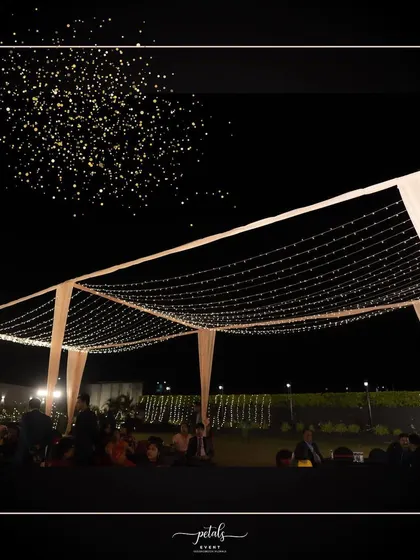 A simple yet stunning fairy light tent creates a magical canopy for a Sangeet night. The twinkling lights against the dark sky provide an enchanting setting for dancing and celebration.