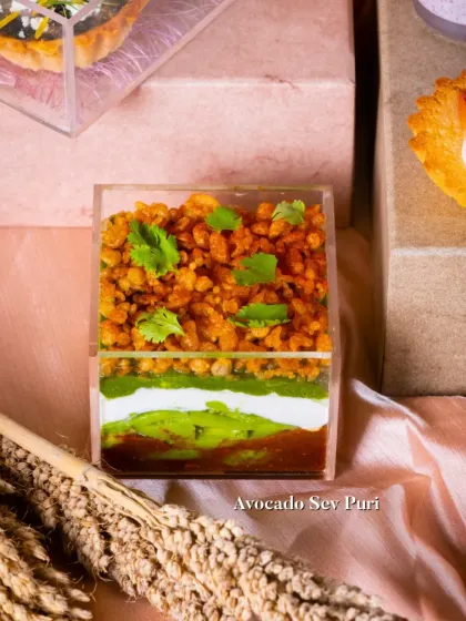 A deconstructed Avocado Sev Puri served in a glass. This modern take on a classic chaat plays with layers, textures, and presentation.
