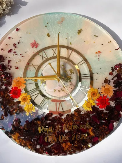 A full view of the colorful garland preservation clock. The mix of different flowers and a two-tone resin background makes this a truly unique piece.