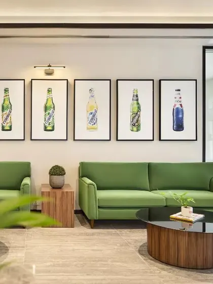 A comfortable waiting lounge at the Carlsberg head office. The design uses brand-aligned colors and curated artwork depicting the company's products to create a space that is both a relaxing area for visitors and a subtle extension of the brand's story.