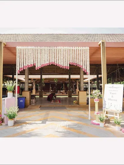Welcoming guests with elegance at Panchavati the Pavilion. The entrance features tuberose and nerium flowers, with a charming welcome board setting the tone for the celebration.