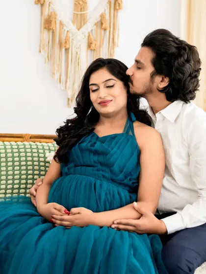 A tender kiss and a gentle embrace. We love capturing these quiet, intimate moments during a couple's maternity photoshoot, preserving the deep connection before the baby arrives.