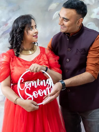 A joyful studio announcement. This happy couple holds a "Coming Soon" sign, sharing their excitement with the world.