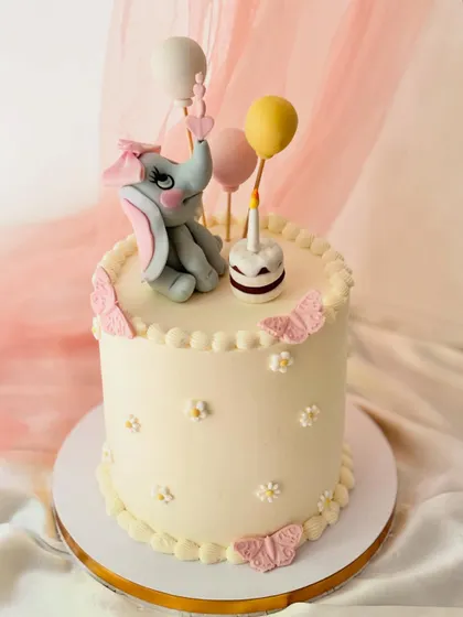 Another view of the adorable elephant first birthday cake. The smooth buttercream finish and detailed fondant work make it a lovely centerpiece.