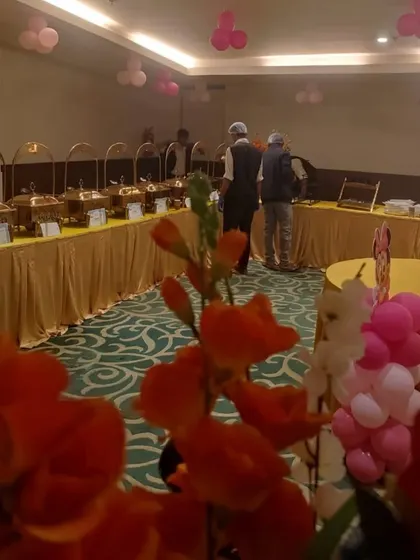 A birthday party setup in an indoor banquet hall. The pink balloon decor shows how we adapt our catering to any private celebration, making it special and memorable.