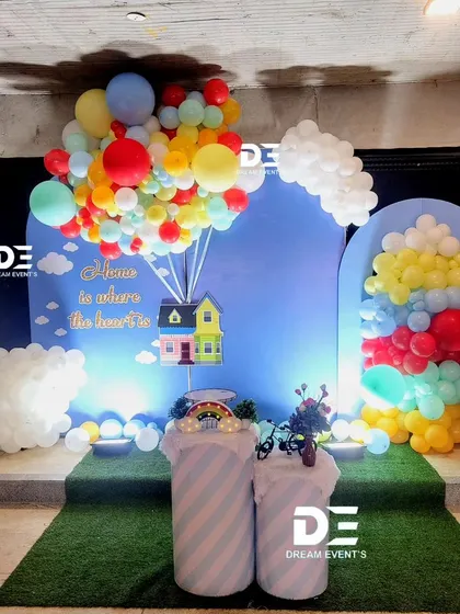 A creative and whimsical housewarming party theme inspired by the movie 'Up', featuring a colorful balloon arrangement lifting a house cutout.