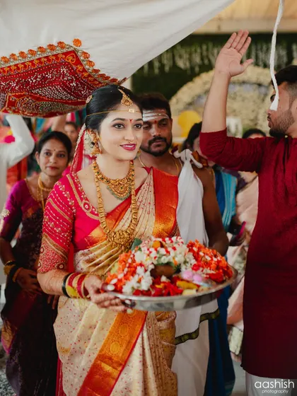 A candid moment from a wedding ceremony. The bride's makeup remains flawless as she participates in the rituals, showcasing its longevity and resistance to humidity.