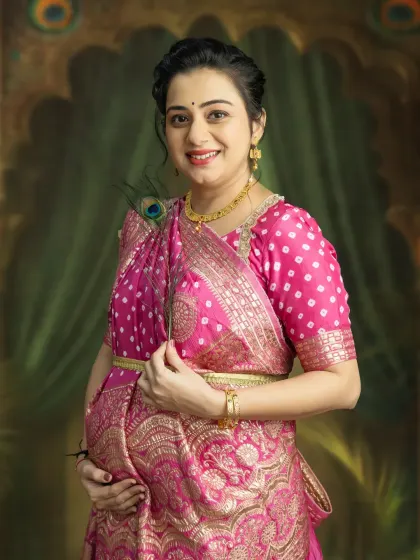 A radiant smile that lights up the room. This close-up shot in a traditional pink saree captures the pure happiness of a mother-to-be.