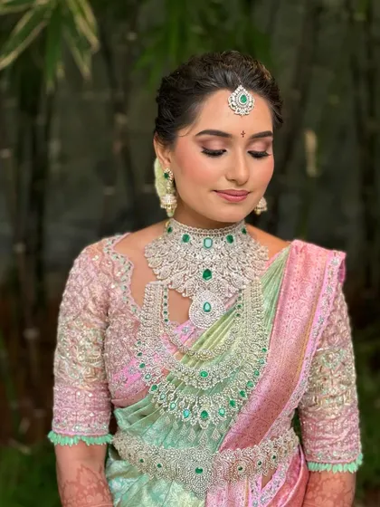 The soft lighting highlights the intricate details of Manasa's makeup and the sparkle of her jewelry.