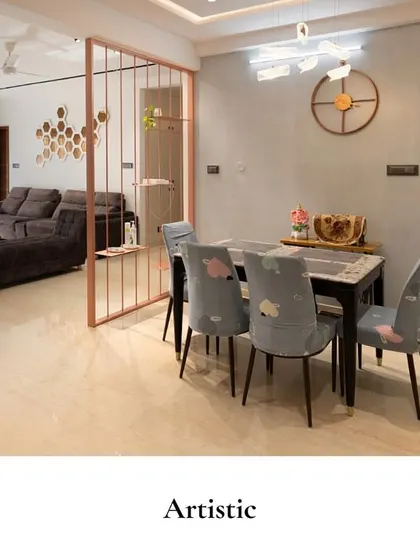 In this dining space, playful chairs with artistic patterns, sculptural pendant lights, and a modern wall clock come together to create a setting full of charm and elegance.