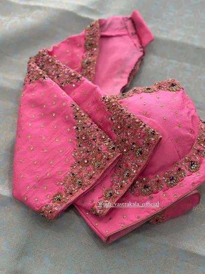 A pink blouse with scattered butis and a simple embroidered border.