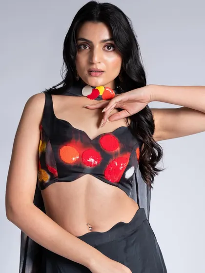 A close-up of a more playful look from the campaign. The makeup is clean and simple, allowing the colorful, abstract print of the top to be the main focus.