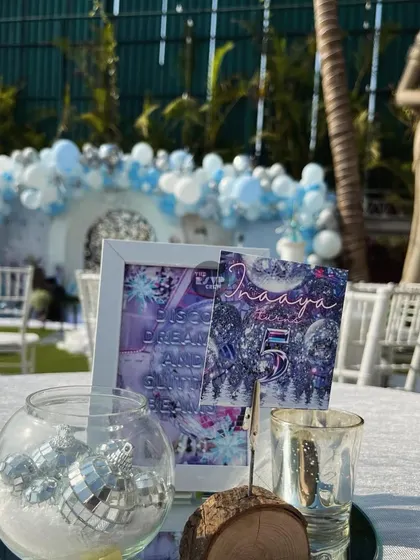 The table centerpieces for the Frozen party included mini disco balls in a glass bowl, reflecting the 'Frozen Disco' theme.