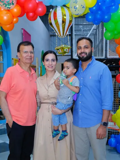 A three-generation family photo capturing a special moment at a birthday party.