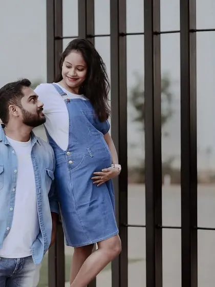 A relaxed and modern maternity shoot with a couple dressed in matching denim. They share a loving look, capturing a casual and authentic moment of their pregnancy journey.