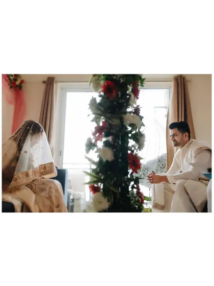 A wide shot of the Nikah ceremony, showing the bride and groom seated before the officiant, capturing the solemnity of the occasion.