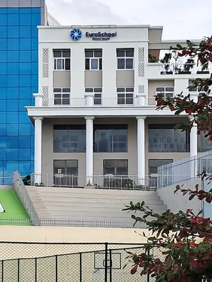 A closer view of the EuroSchool facade and the adjacent tiered seating area, which serves as a small amphitheater for outdoor events.