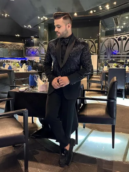An elegant, full-length shot of the client in our striped sequin tuxedo, showcasing the complete, tailored look.