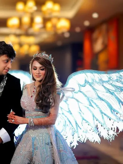 The couple together, with the bride's illuminated angel wings creating a magical glow. This is a perfect example of how we create one of a kind, fantasy like portraits.