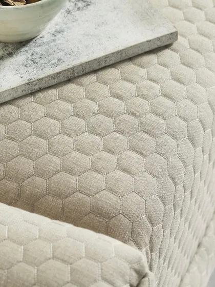 A top-down detail shot of the hexagonal quilted pattern on the bench. This provides a clear view of the fabric's unique texture, a key selling feature.