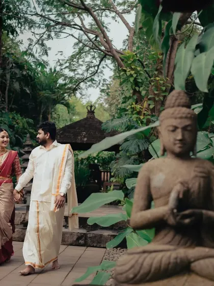A post-wedding stroll through a serene, temple-like garden. This shot captures the couple hand-in-hand, embarking on their new journey together.