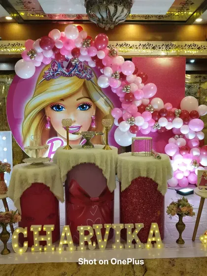 For this first birthday, I created a glamorous Barbie theme. The setup includes a large circular Barbie backdrop, a cascading pink balloon arch, and a custom light-up marquee name for the birthday girl.
