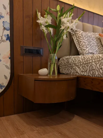 A close-up of the custom floating bedside table, designed with curved edges to soften the room's aesthetic.
