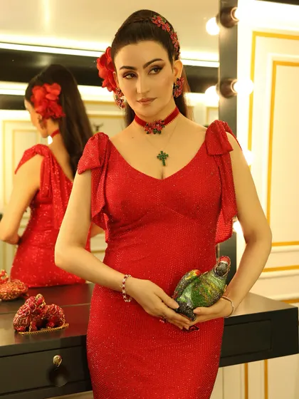 It's all in the accessories. The parrot clutch by Judith Leiber was the perfect playful element to complement the elegant red gown and floral hair accessories.