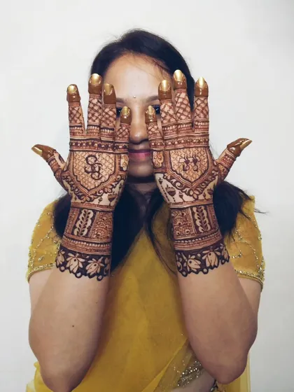 A sweet engagement design with the couple's initials and a depiction of them on a swing. It’s these little personal stories that make the mehndi truly special.