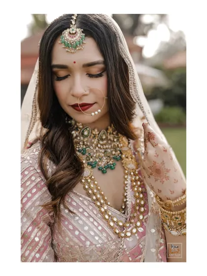 A close-up bridal portrait focusing on the intricate jewelry and flawless makeup.