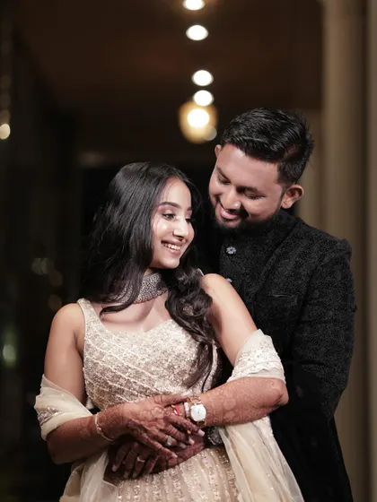 A sweet, smiling portrait of the couple. Her makeup is soft and glamorous, perfect for an evening celebration.