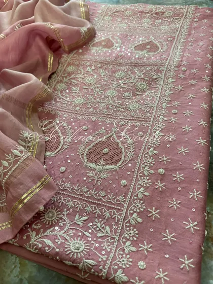 Another angle of the laid-out suit, focusing on the paisley motifs and the delicate seed pearl detailing.