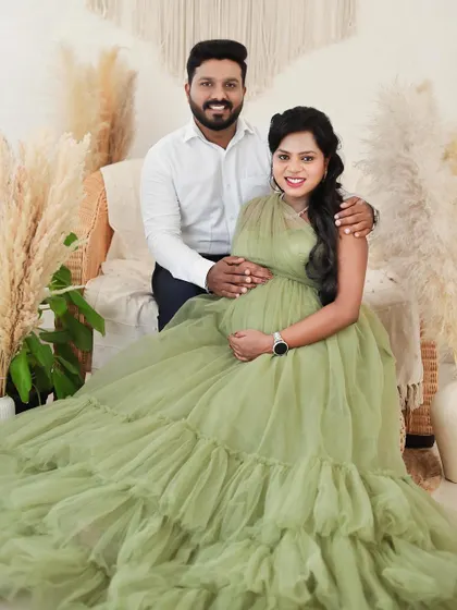 A happy, seated portrait of a couple in our boho studio. The neutral tones of the set design complement any outfit choice.