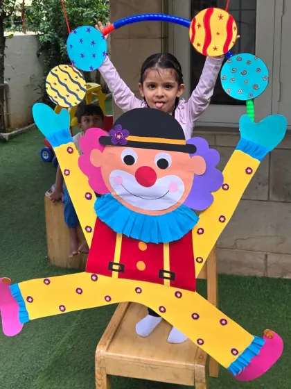 This little Aster is having a blast posing with the big clown craft. These moments of pure fun are what make summer camp so memorable.