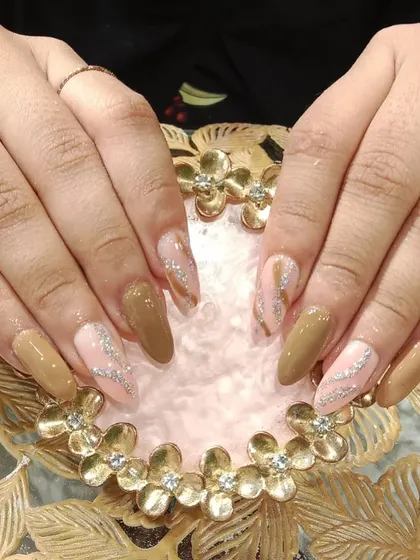 An earthy and chic design combining solid brown nails with a sheer pink base and a swirl of silver glitter.