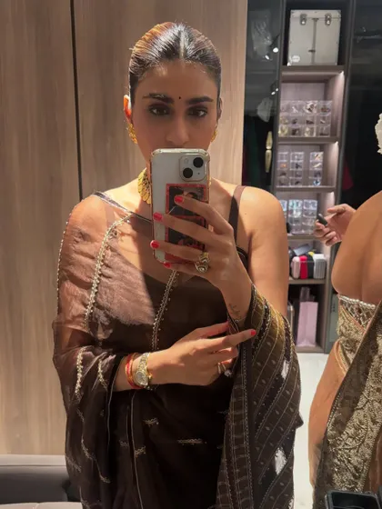 A mirror selfie in a simple yet chic brown saree. This look is all about understated elegance, perfect for a more intimate gathering.