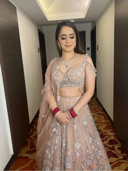 A bride ready for one of her pre-wedding functions, with her hair styled in simple, elegant, open waves. This look is perfect for a Roka or engagement ceremony.