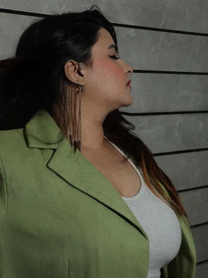 Another angle of the model in the green blazer, capturing a moment of reflection with soft, focused lighting.