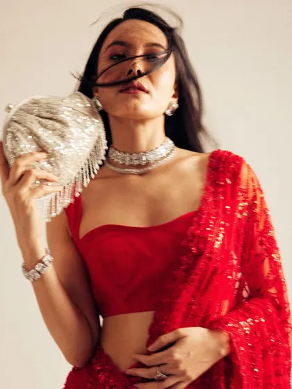A dynamic shot showing the movement of the hair. Even with motion, the simple, open hairstyle maintains its elegance and complements the vibrant red saree.